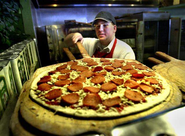 Giovanni's Old World New York Pizza manager prepares pepperoni pizza for the oven in 2002. 